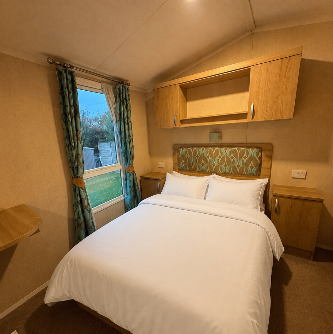 Double bedroom with made-up bed and garden view